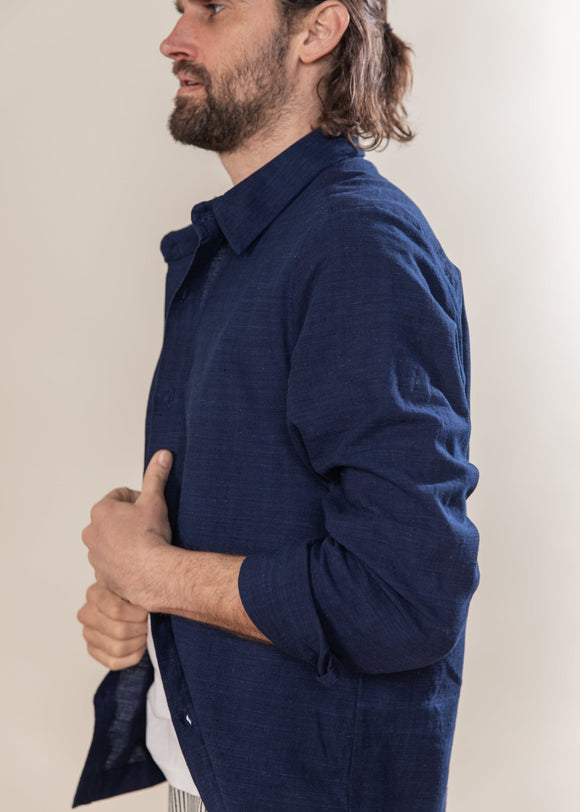 Man wearing a blue shirt against a plain background