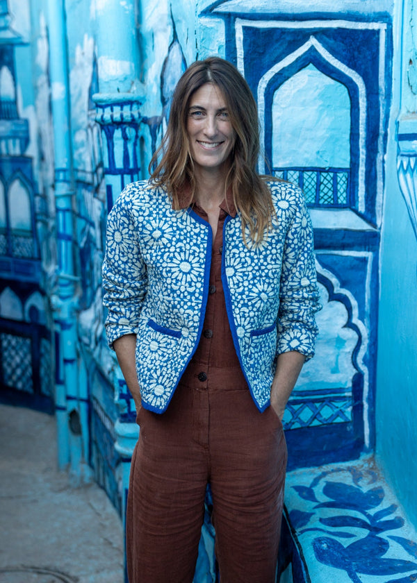Woman standing in front of a blue and white architectural mural