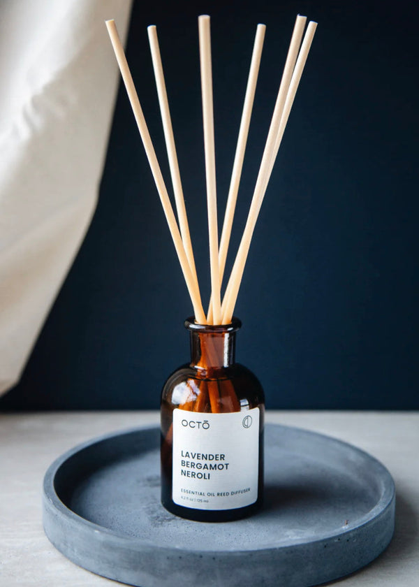 octo reed diffuser in bottle on a grey plate