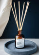 octo reed diffuser in bottle on a grey plate