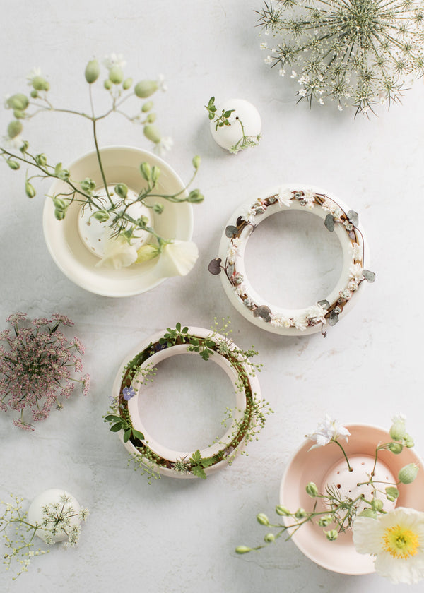 Decorative ceramic bowls with floral arrangements on a light surface