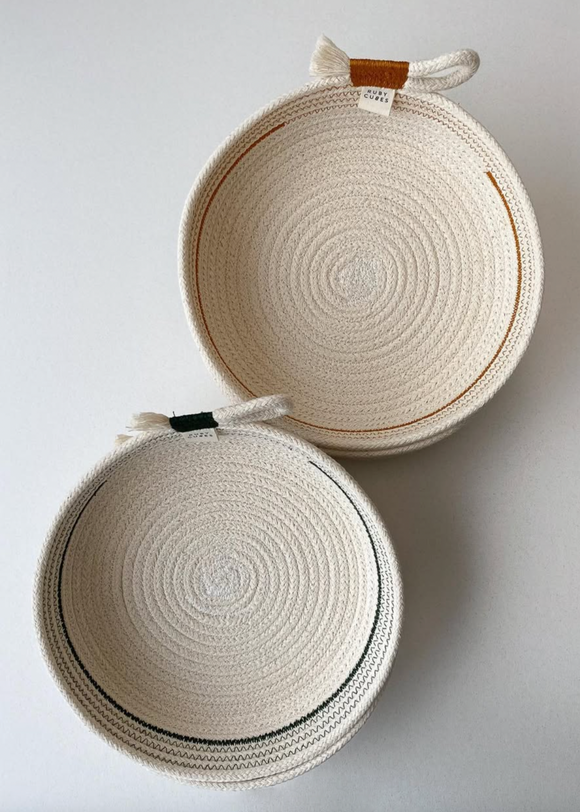 Two round woven baskets with handles on a light gray background