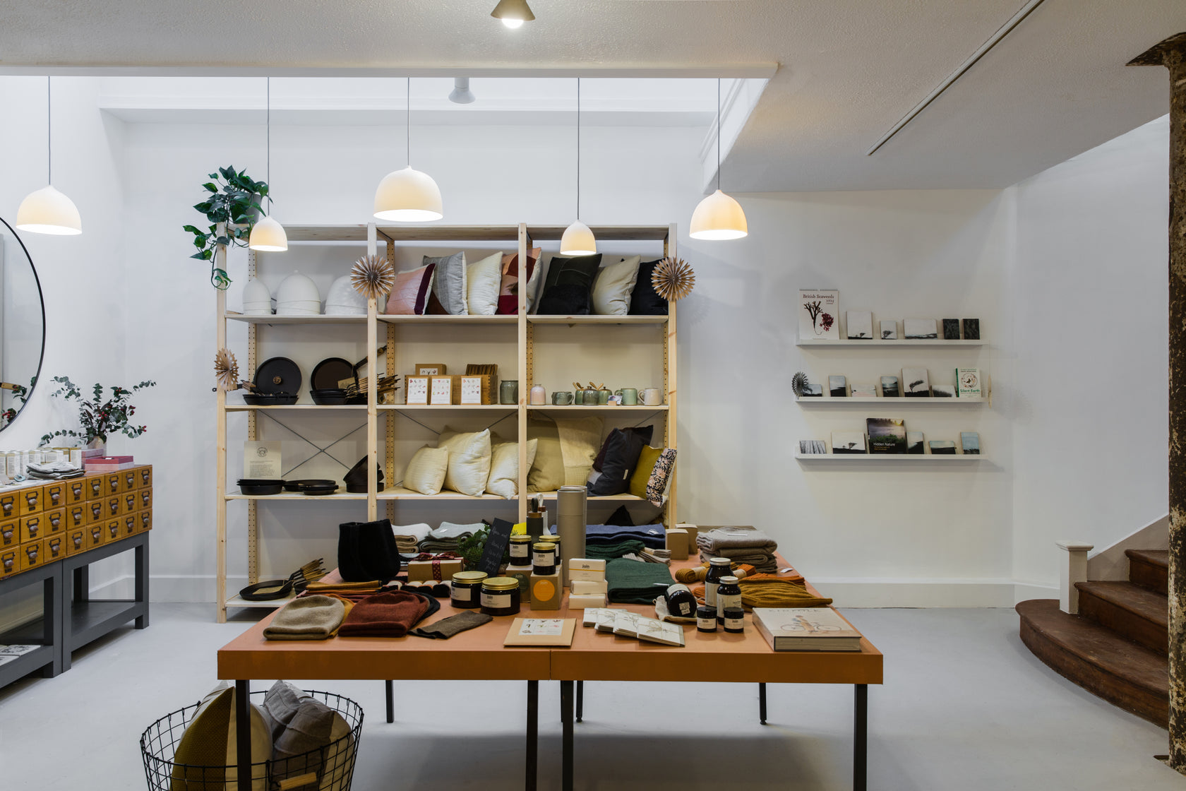 Interior of a store with shelves displaying various items and a table with more products.
