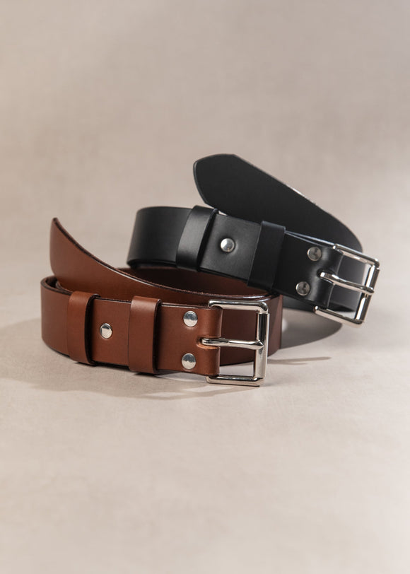 Two leather belts, one brown and one black, on a beige background.