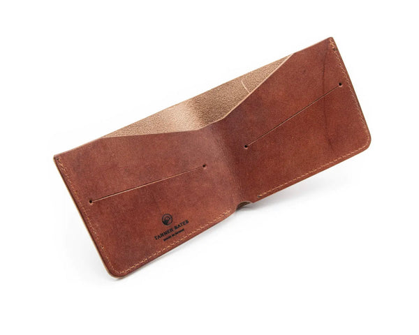 A brown Tanner Bates Yarmer Billfold Wallet made of leather, open and displaying the interior with multiple card slots.