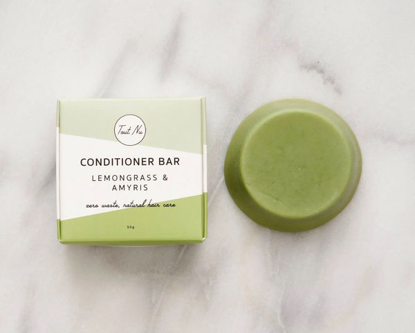 Green conditioner bar and packaging on a marble surface