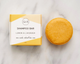 Shampoo bar and packaging with 'Tout Nu' branding on a light background