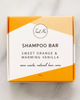 Box of Tout Nu shampoo bar with orange and white design on a light gray background