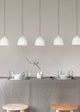Dining table setting with pendant lights against a plain wall