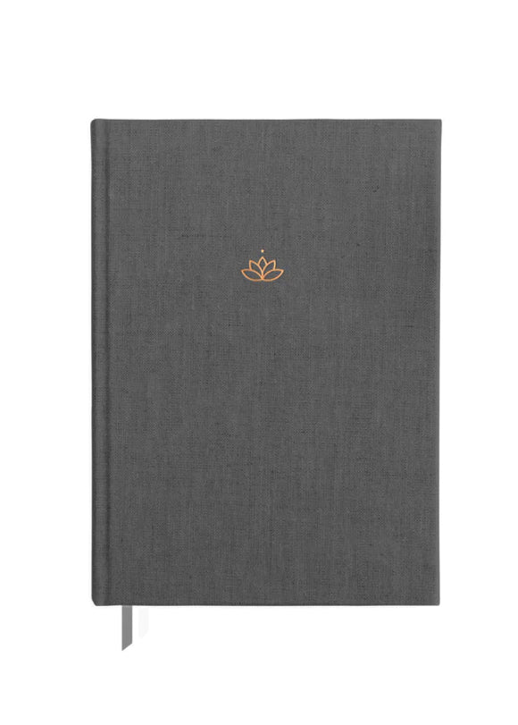 A closed weekly planner with a gray fabric cover, featuring a subtle lotus flower emblem near the top. It has a bookmark attached to the side.