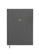 A closed weekly planner with a gray fabric cover, featuring a subtle lotus flower emblem near the top. It has a bookmark attached to the side.
