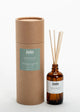 A luxury botanical room diffuser by Join, featuring a brown cylindrical packaging and a amber glass bottle with diffuser sticks inside. The label on the bottle reads 'Hedgerow'.