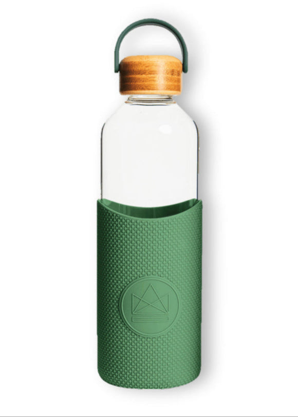Clear water bottle with green sleeve and wooden cap on a white background